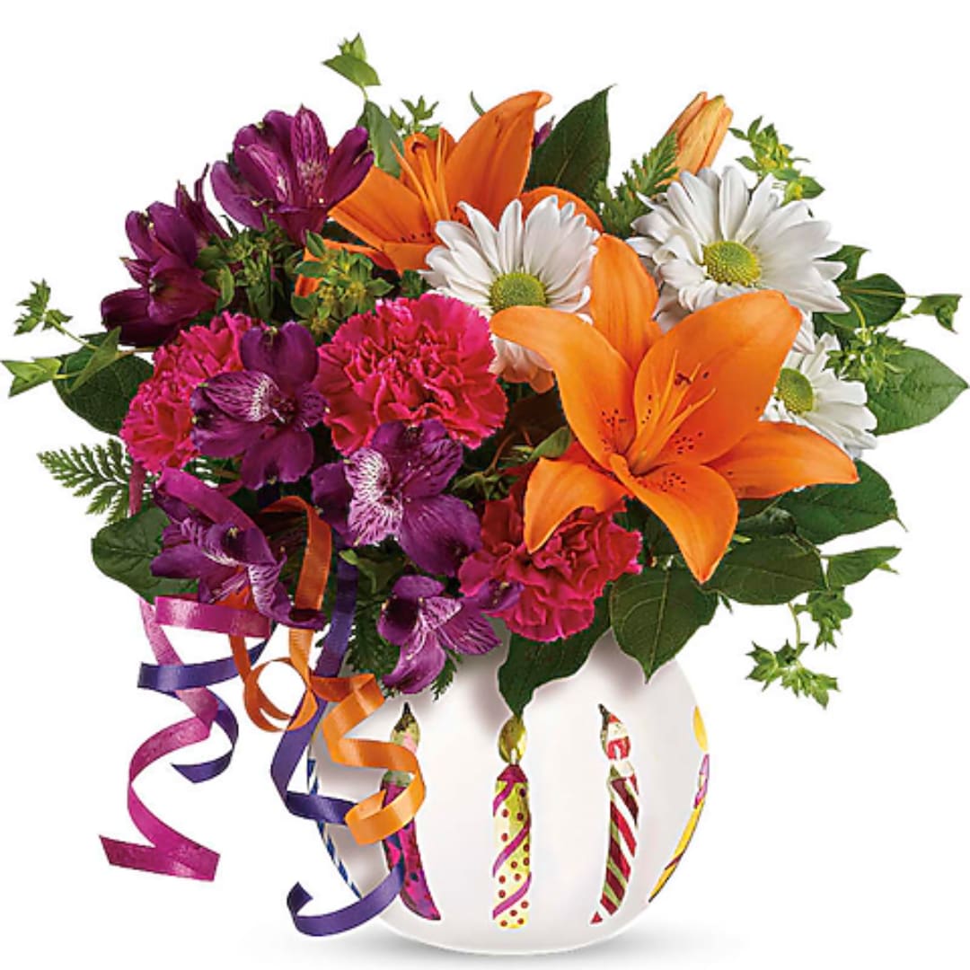Colorful bouquet of lilies, daisies, and carnations in a white vase with ribbon curls