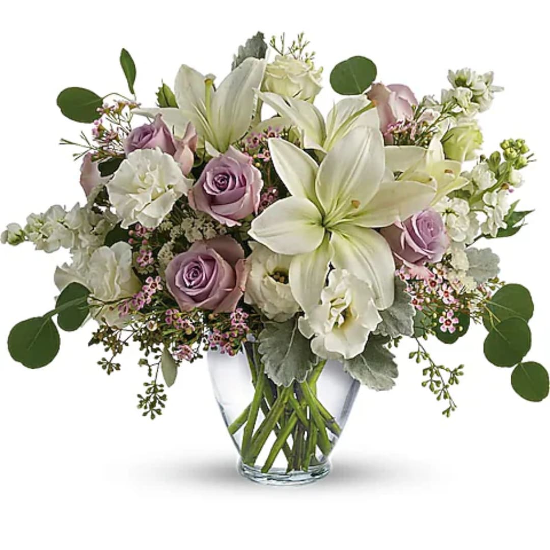 Lavender roses and white lilies in a clear glass vase