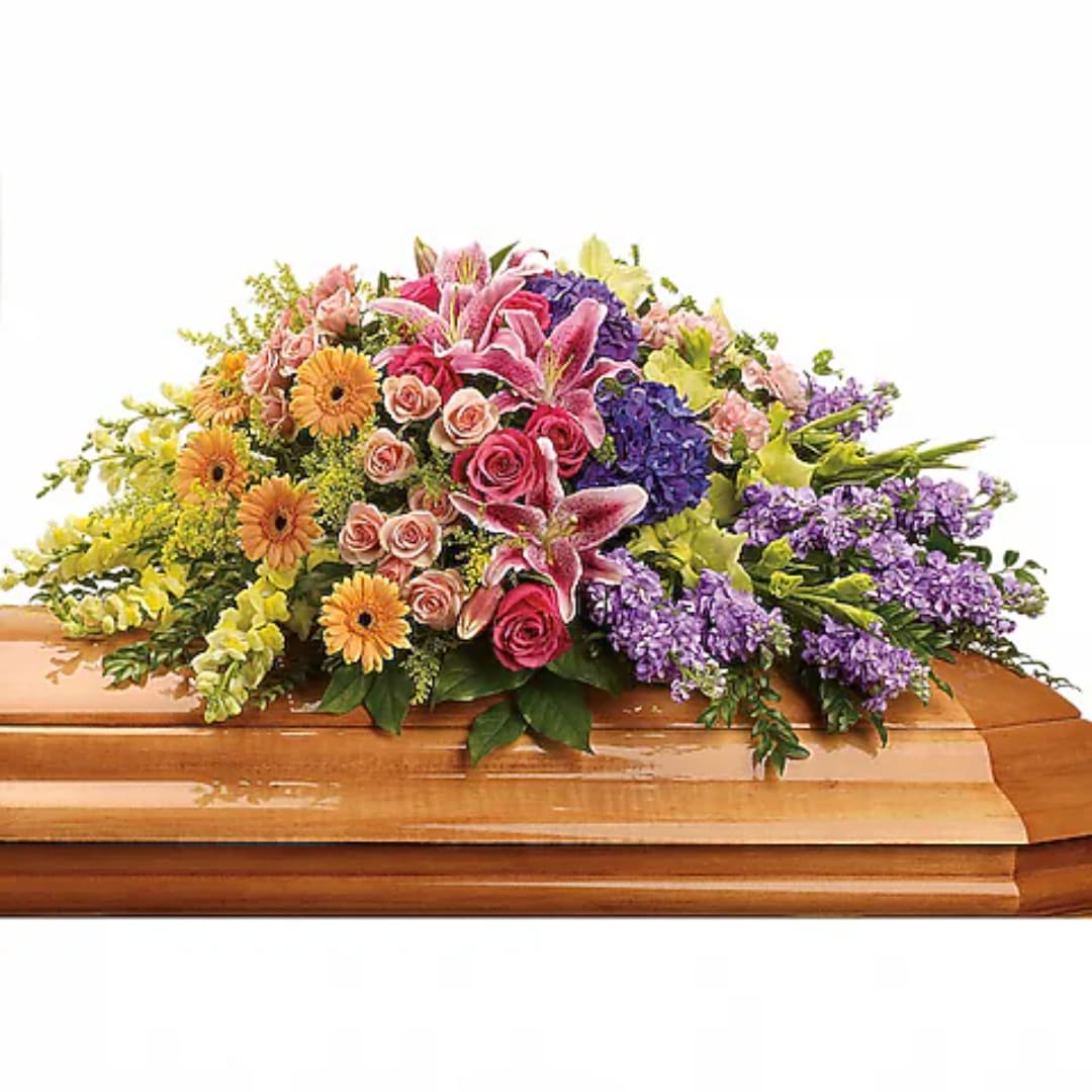 Colorful floral casket spray with lilies, roses, and daisies