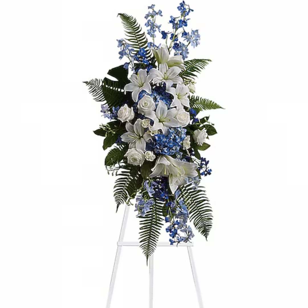 White lilies and blue flowers arranged on a standing easel