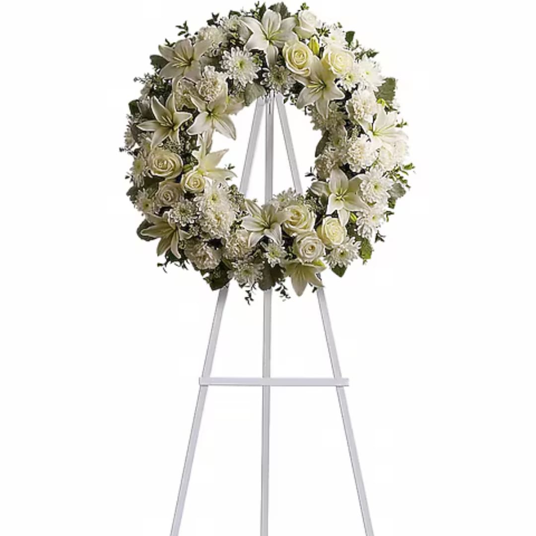 White floral wreath on a white easel stand