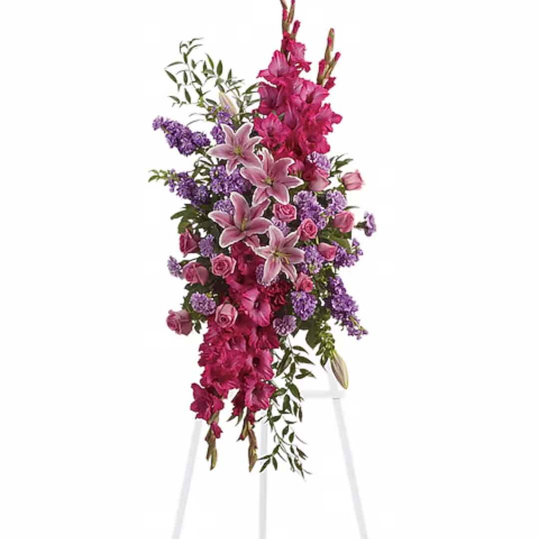 Tall pink and purple floral arrangement on a white stand
