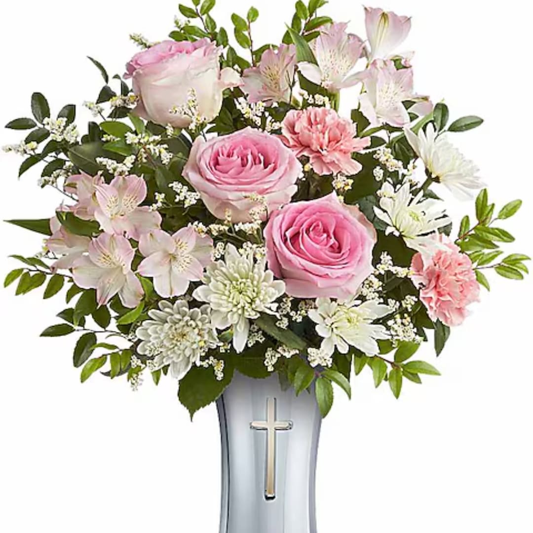 Pink roses and white flowers arranged in a vase with a cross emblem