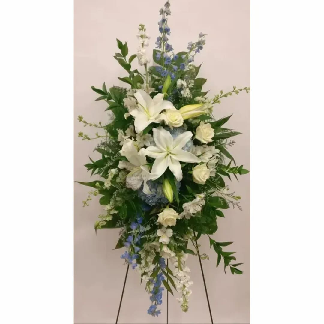 Tall white and blue floral standing spray on an easel