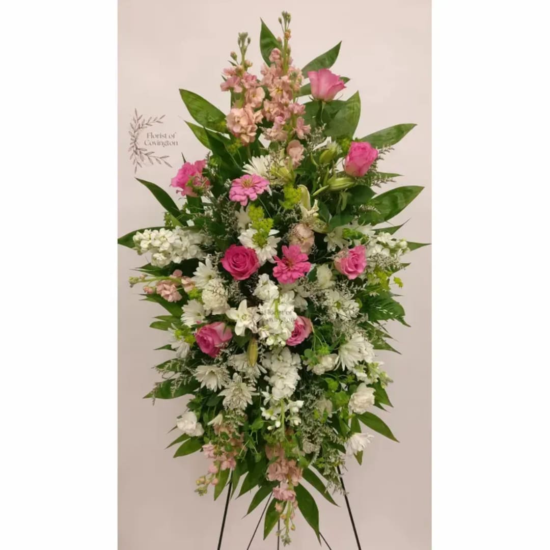 Standing floral spray with pink and white flowers on a metal easel