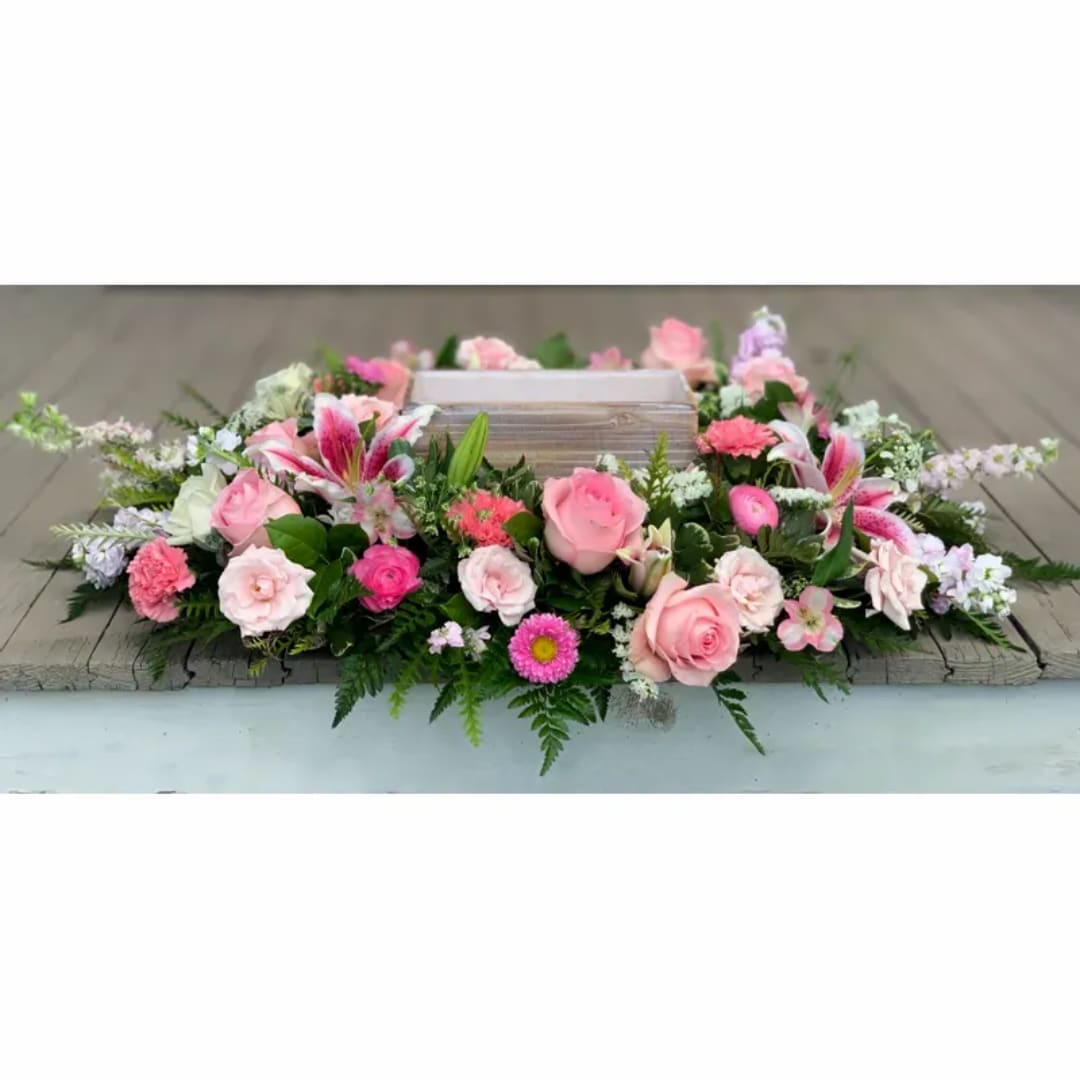 Pink and white floral wreath around a wooden box