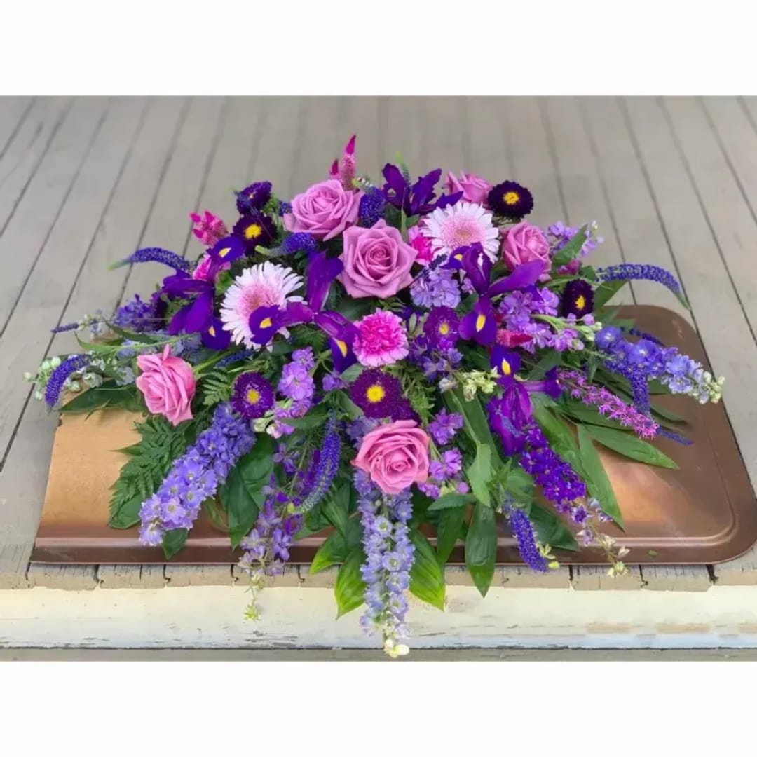 Purple and pink floral arrangement on a tray