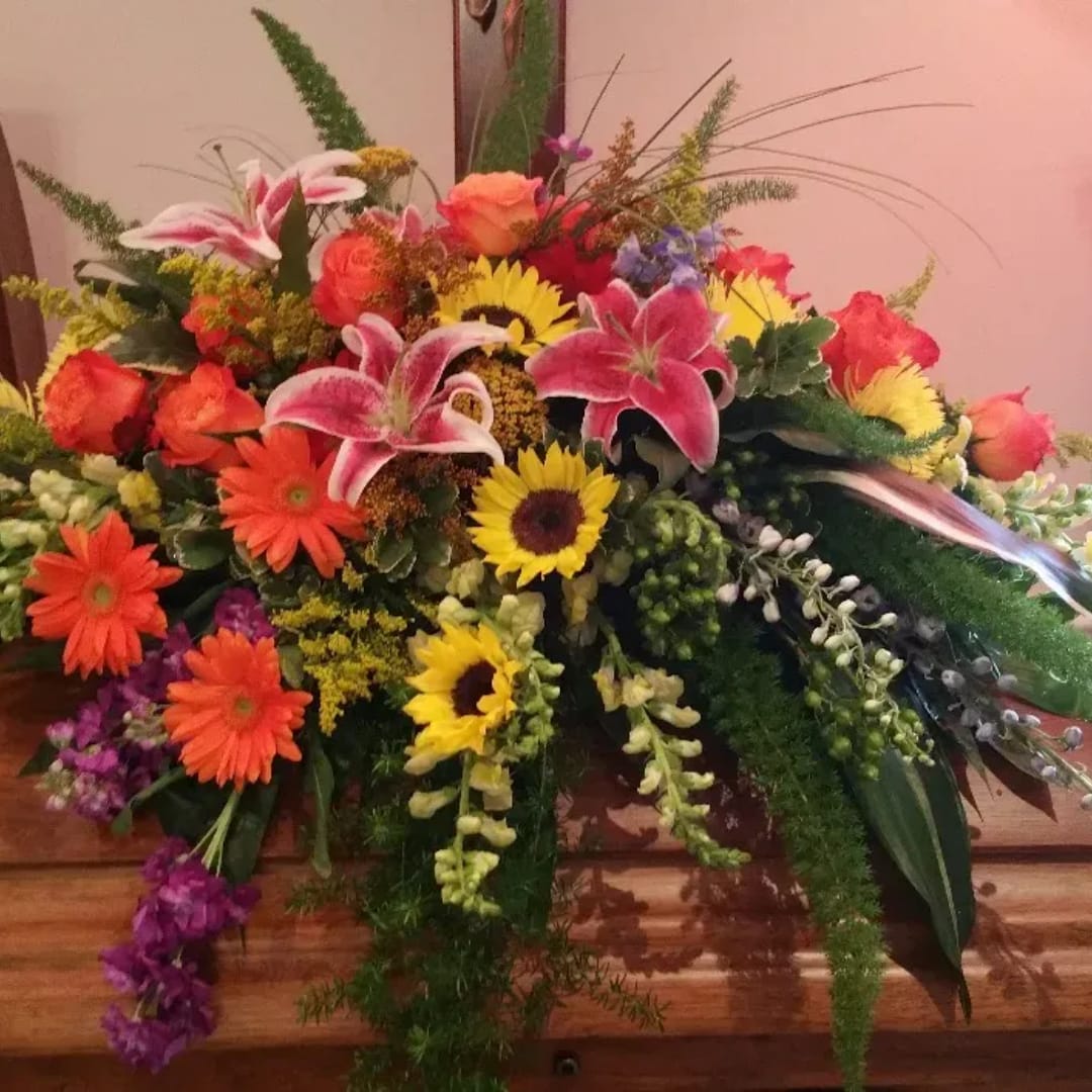 Colorful mixed flower arrangement with lilies, roses, sunflowers, and gerbera daisies