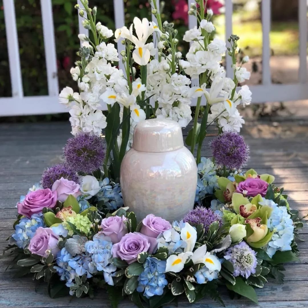 White floral wreath with lavender roses and a ceramic urn centerpiece