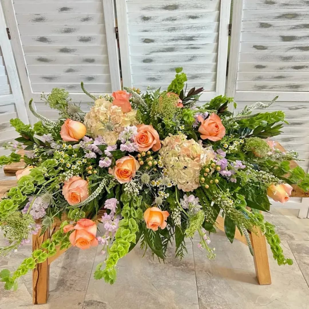 Peach roses and cream hydrangeas arranged on a wooden table