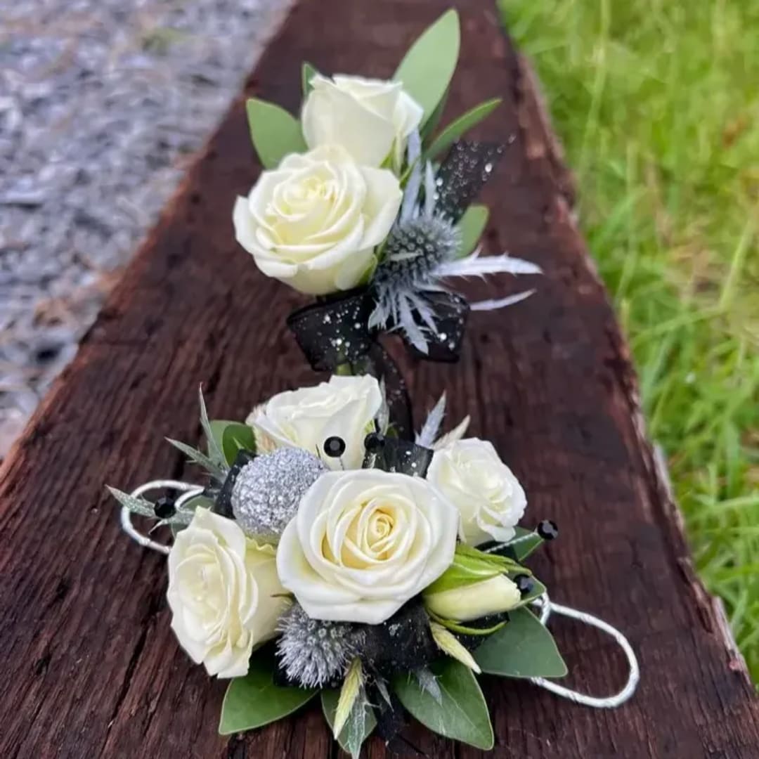 White rose corsage and boutonniere set with black ribbon accents