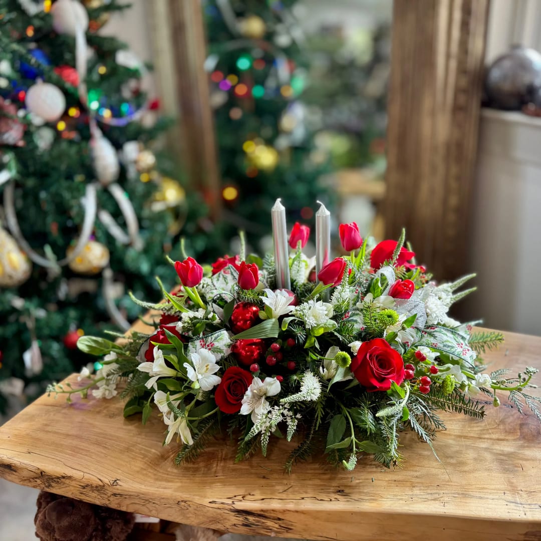 Red roses and white flowers arranged with silver candles