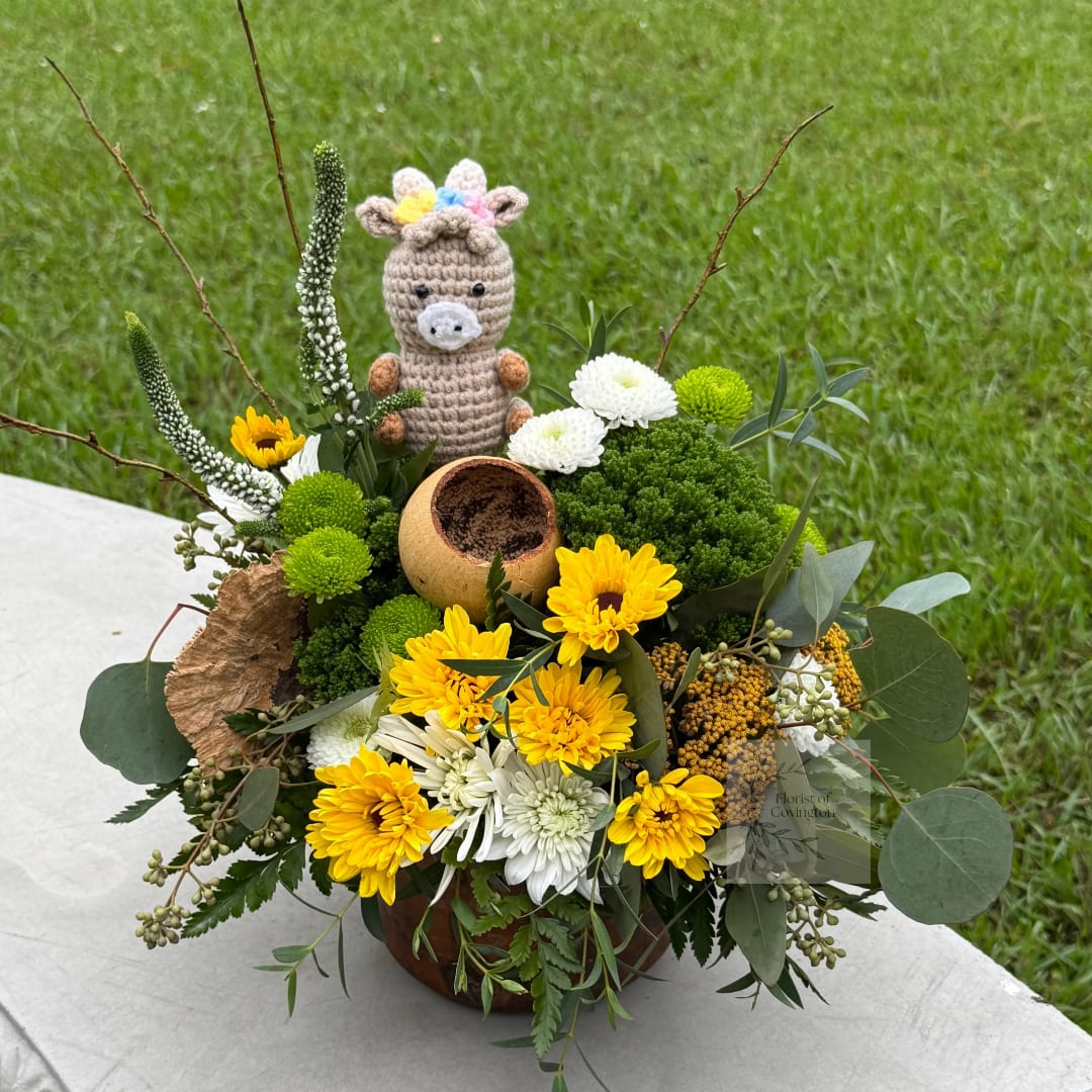 Yellow and white flower arrangement with a crocheted animal topper in a bowl vase