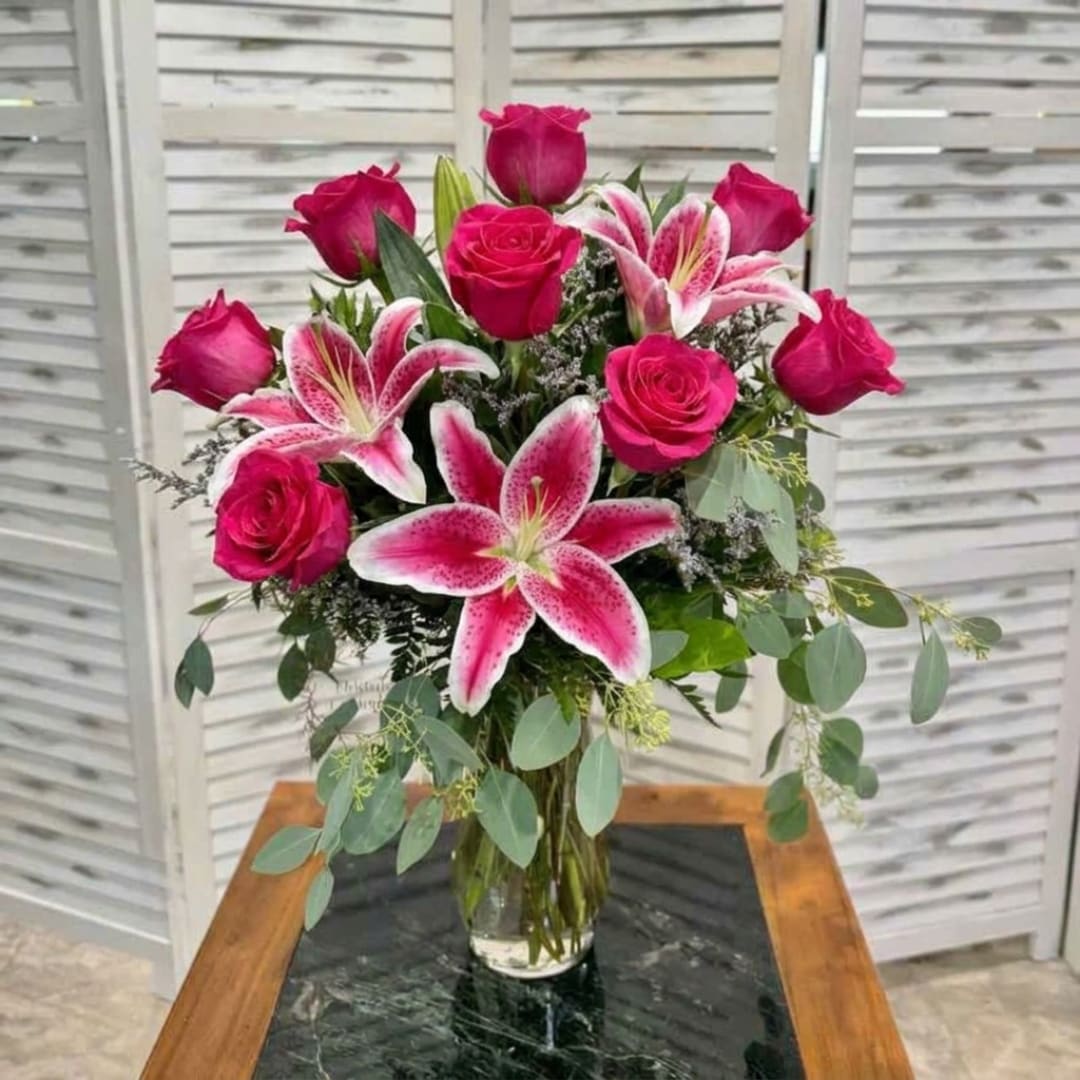 Pink roses and stargazer lilies in a clear glass vase