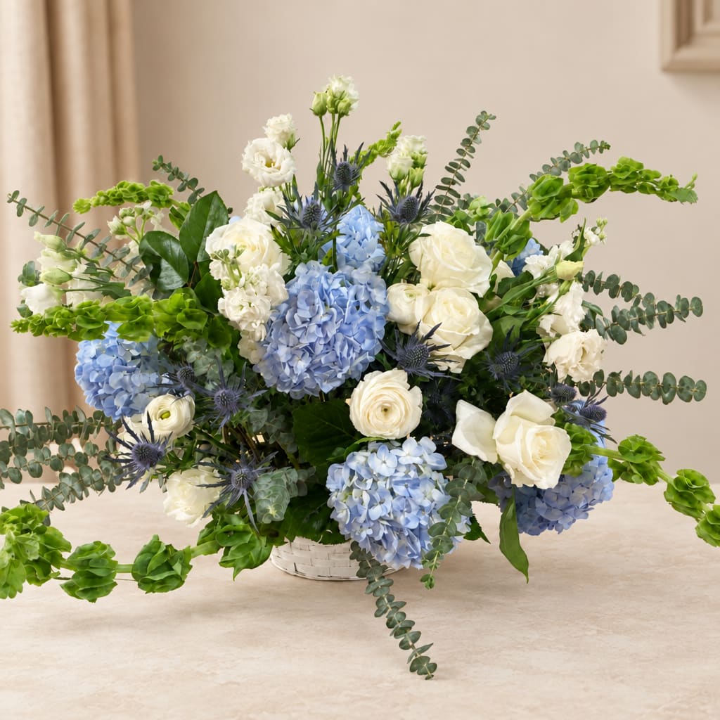 Blue hydrangeas and white roses in a white basket vase