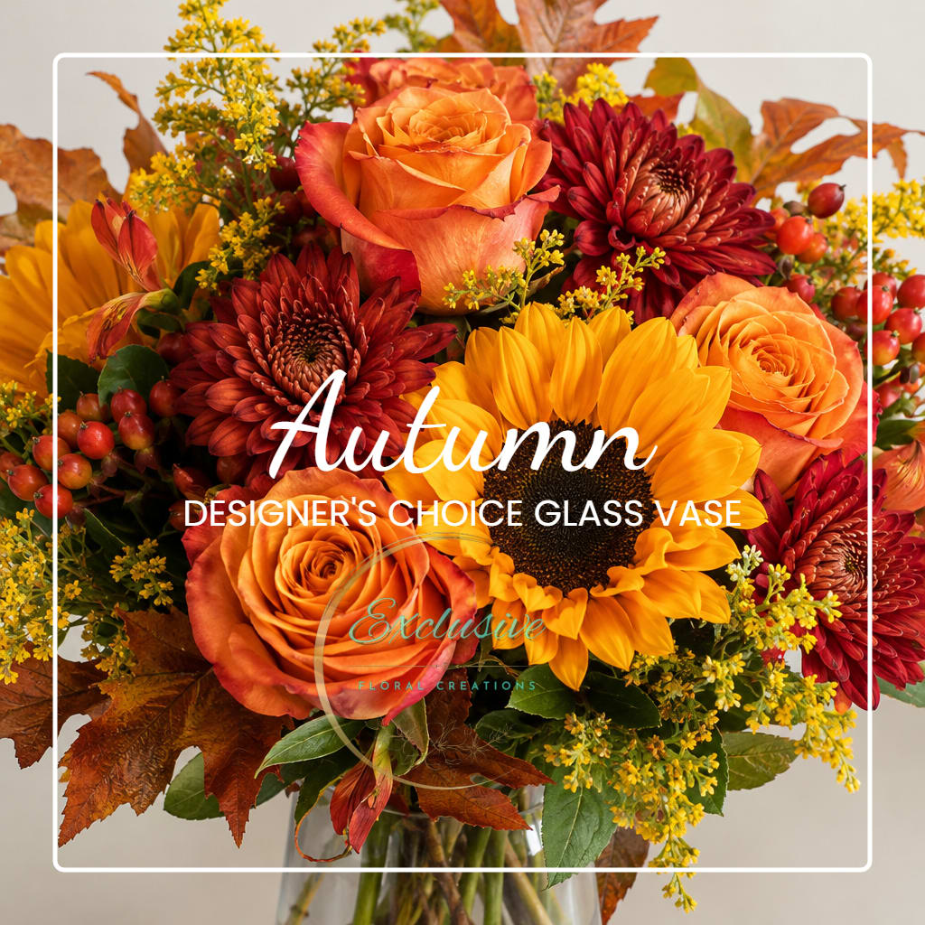 Autumn bouquet of orange roses, sunflowers, and red mums in a glass vase