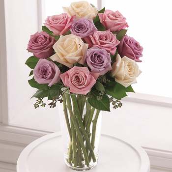 The Pastel Passion Rose Bouquet - A delightful study in pastels, this collection of pale pink, blush, pale yellow and pale lavender roses makes an exquisite bouquet. All are arranged with fragrant seeded eucalyptus in a classic clear glass vase.