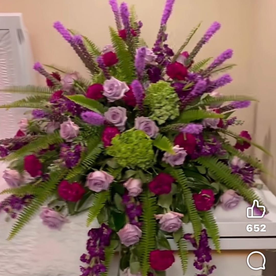 Large bouquet of purple and pink roses with green hydrangeas and fern fronds