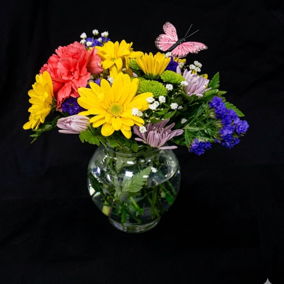 Mixed bouquet of daisies and carnations in a clear glass vase
