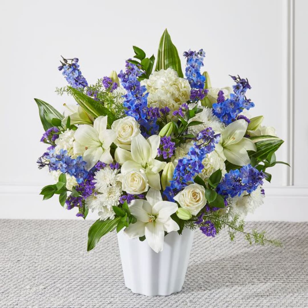 White and blue floral arrangement in a white vase