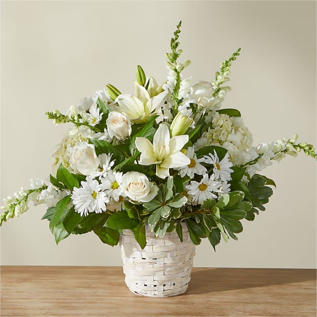 White floral arrangement in a white woven basket