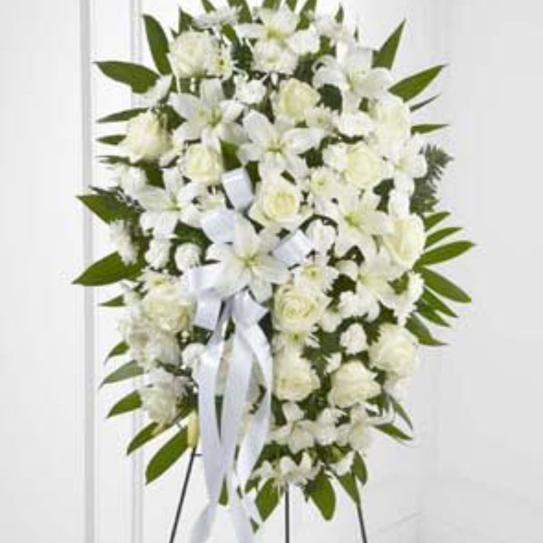 White floral standing spray with ribbon on an easel