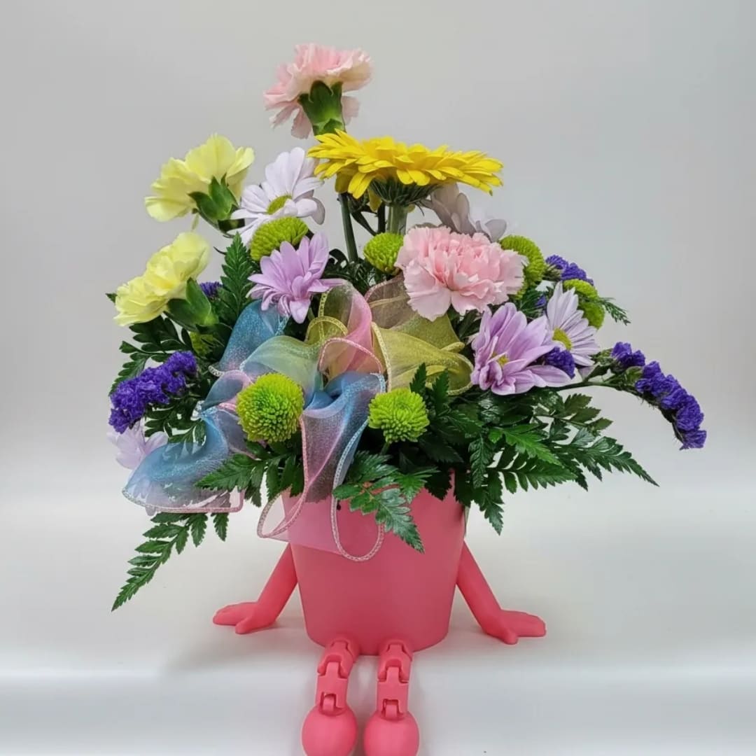 Colorful flower arrangement in a pink pot with small legs and arms