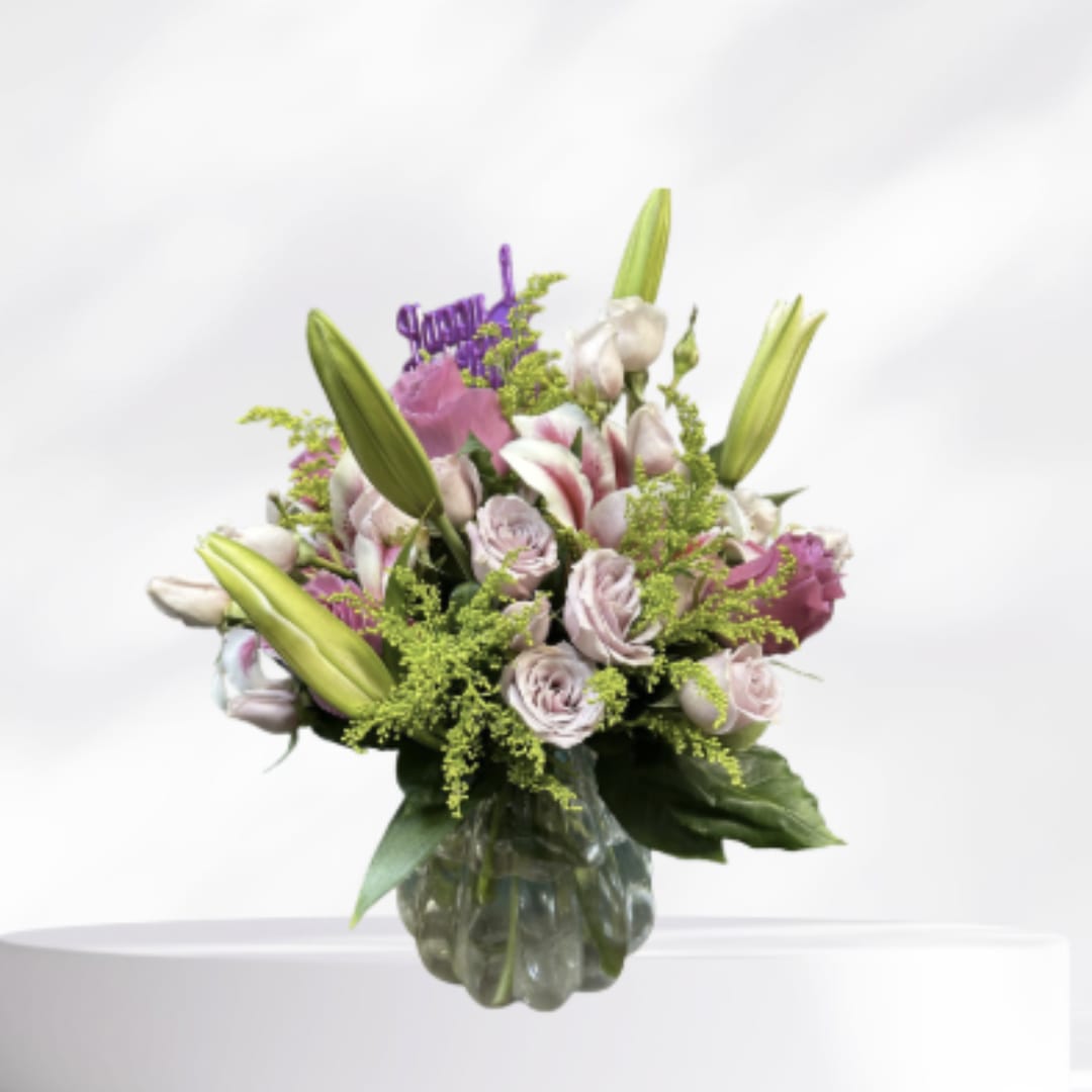 Pink and white bouquet with lilies and roses in a glass vase