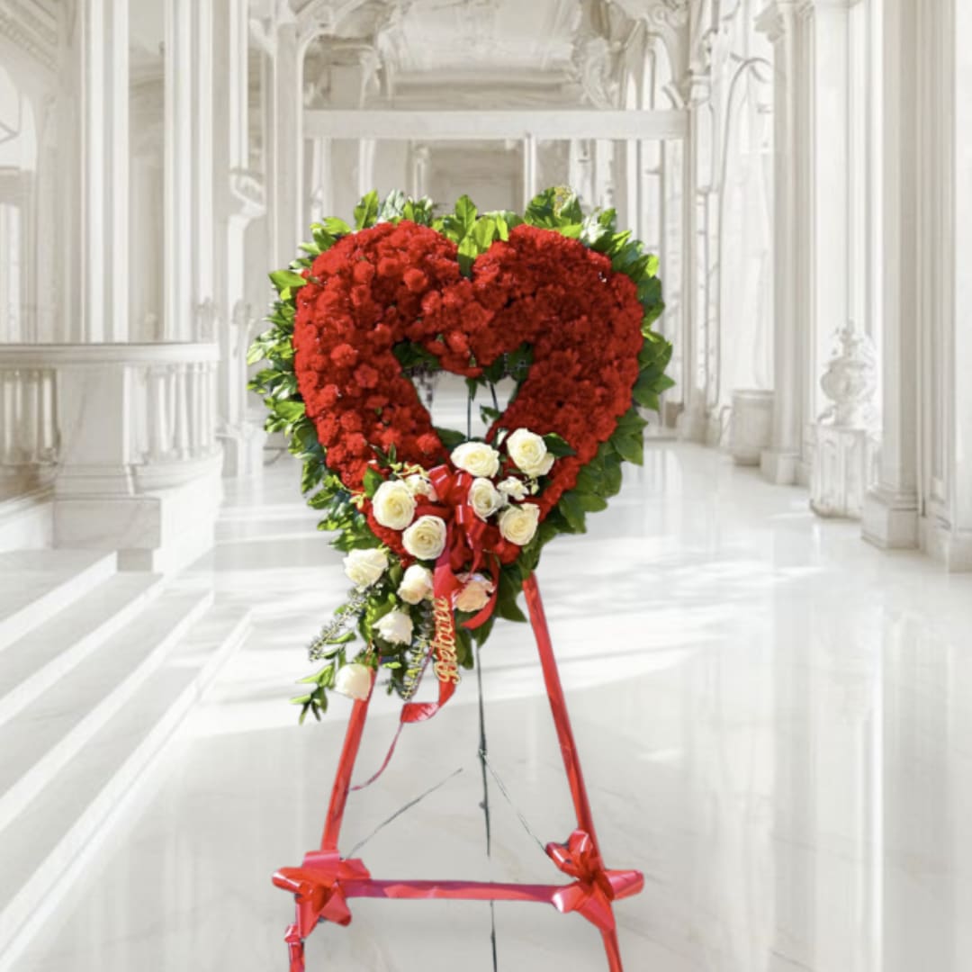 Heart-shaped red floral standing spray with white roses on an easel