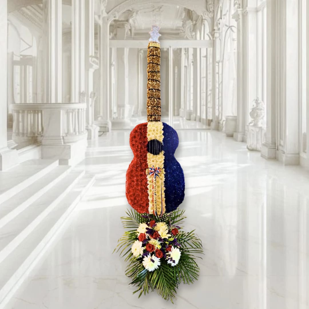 Standing floral guitar display in red, white, and blue with flowers at the base