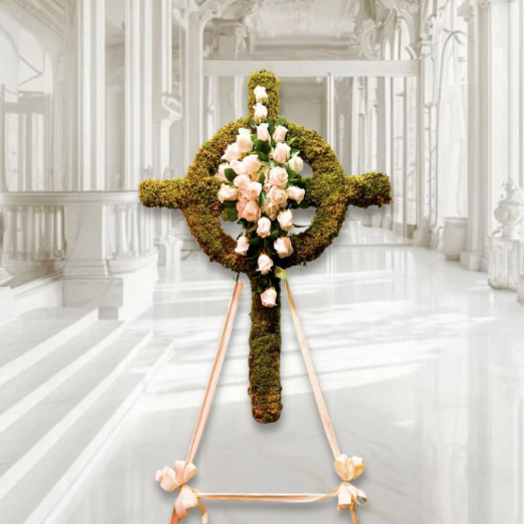 Floral cross covered in moss with pale pink roses