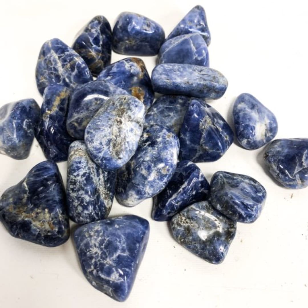 Pile of polished blue stones with white veining on a white background