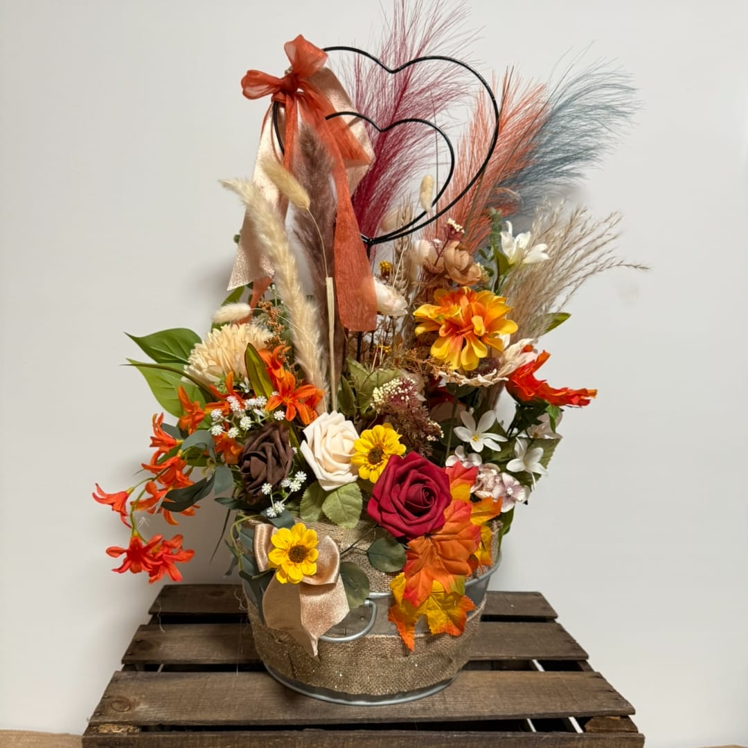 Autumn floral arrangement in a metal bucket with heart topper and ribbon