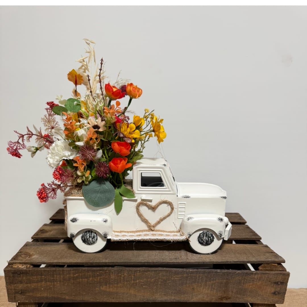 White decorative truck filled with colorful flowers