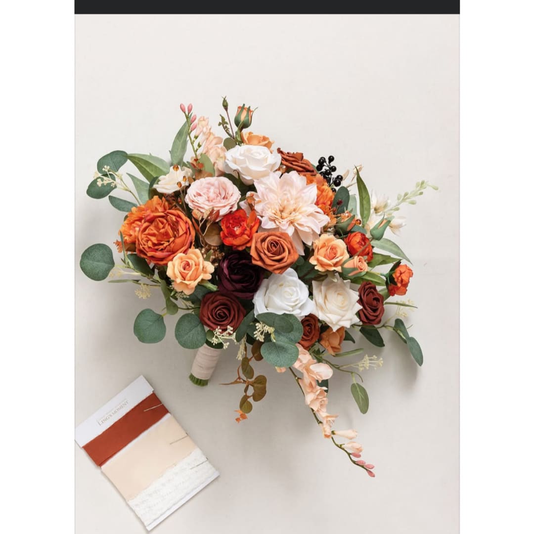 Bouquet of orange, peach, white, and burgundy roses with greenery