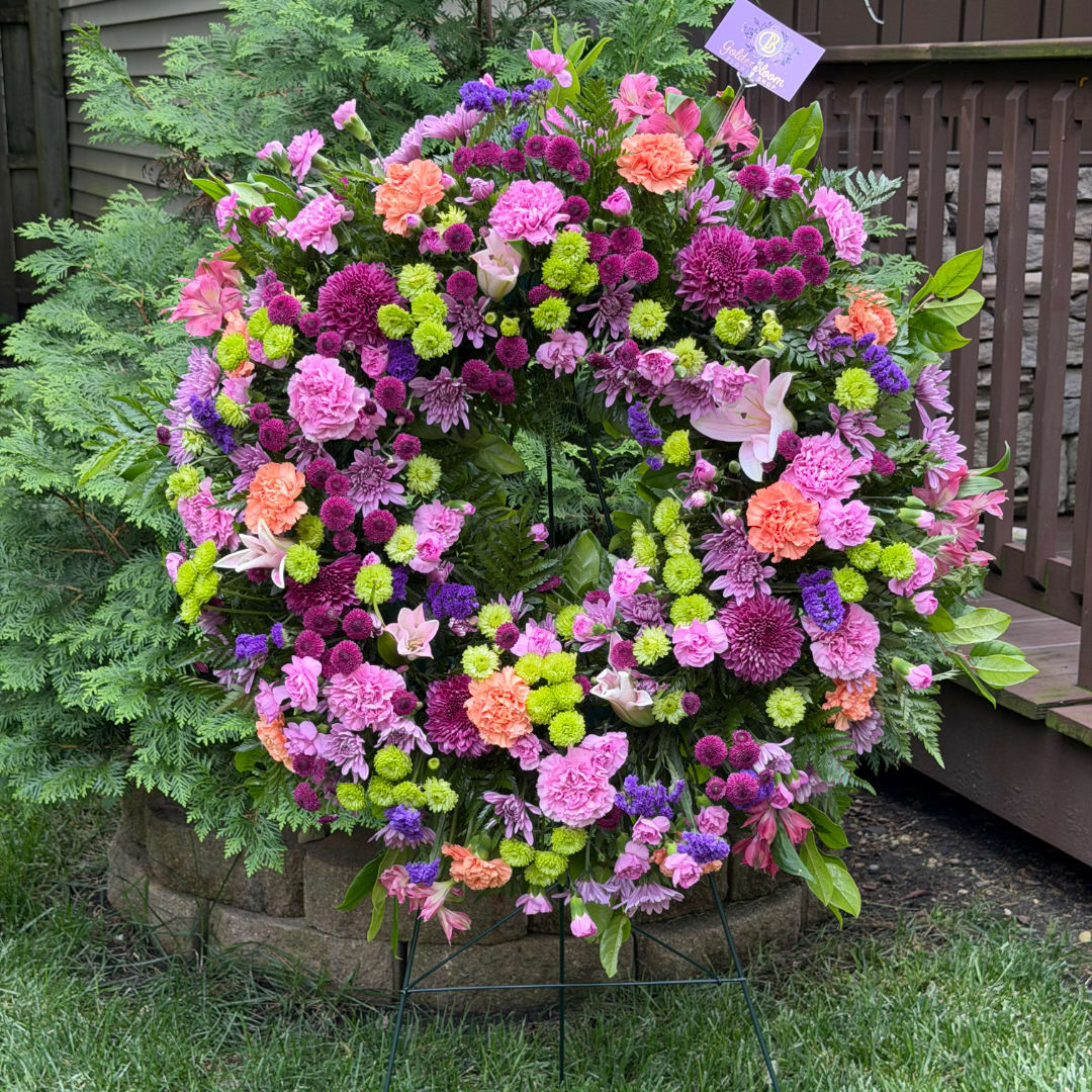 Large circular floral wreath with pink, purple, and orange blooms
