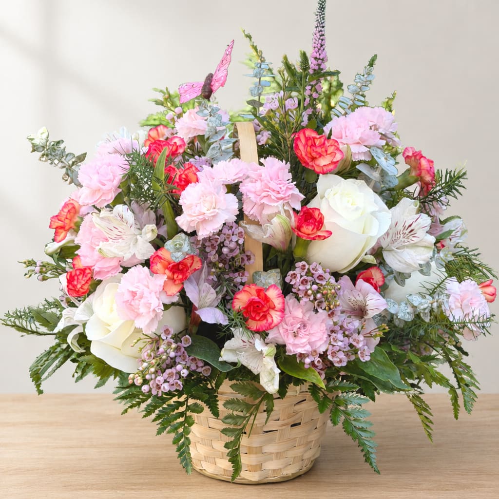 Pink and white flower arrangement in a woven basket