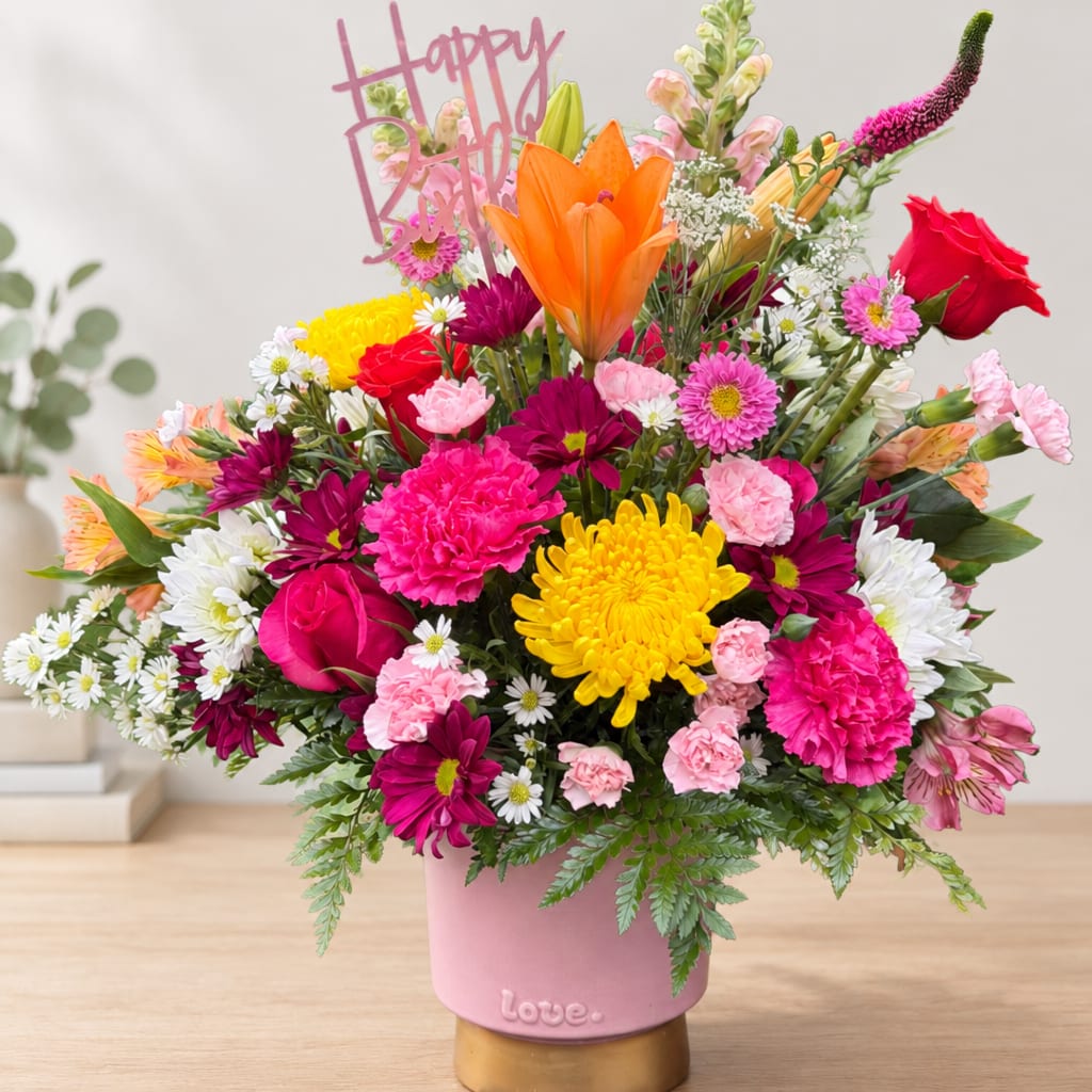 Colorful mixed bouquet in a pink vase with a Happy Birthday topper