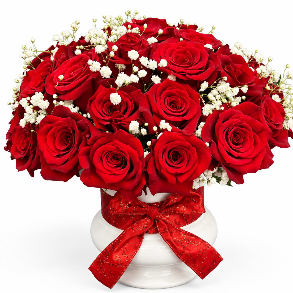Red roses and white baby's breath in a white vase with a red ribbon