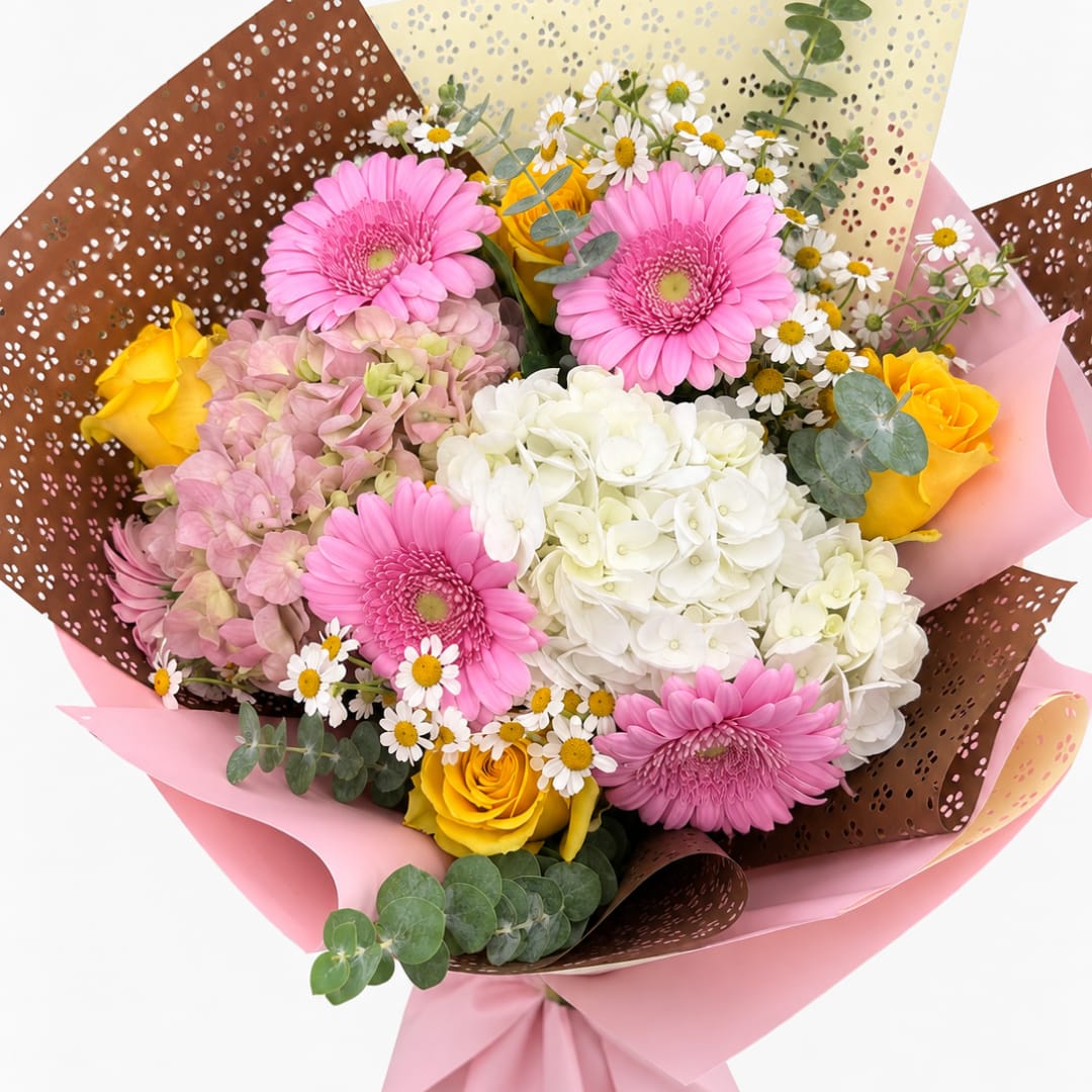 Bouquet of pink gerbera daisies, white hydrangea, and yellow roses
