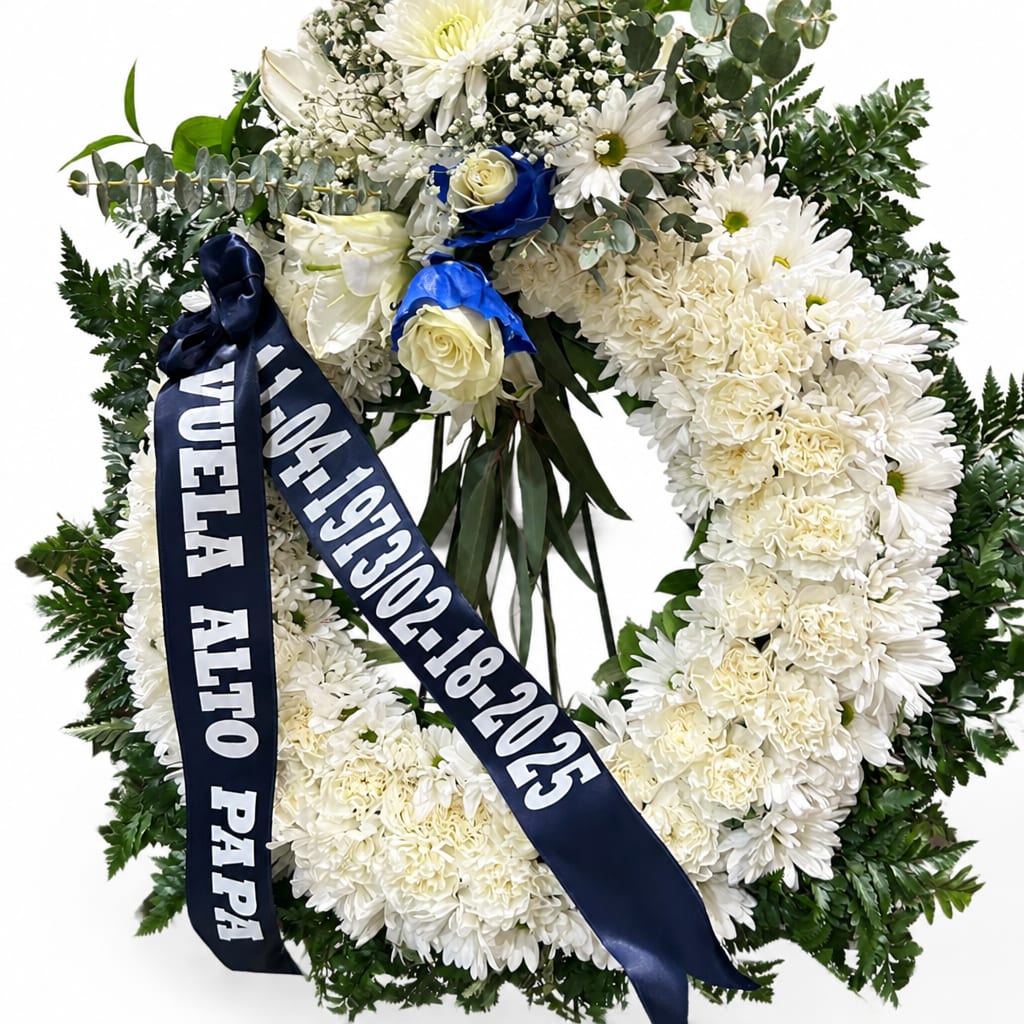 White floral funeral wreath with blue ribbon and roses
