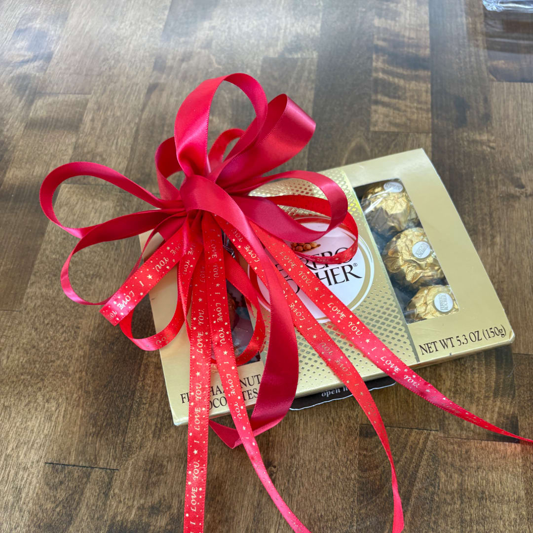 Box of Ferrero Rocher chocolates tied with a large red ribbon