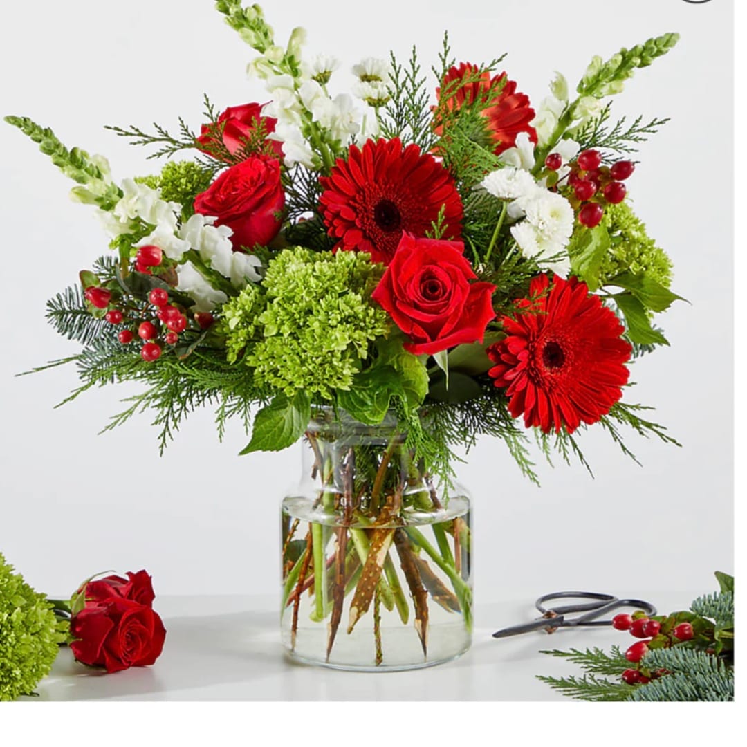 Red roses and gerbera daisies in a clear glass vase