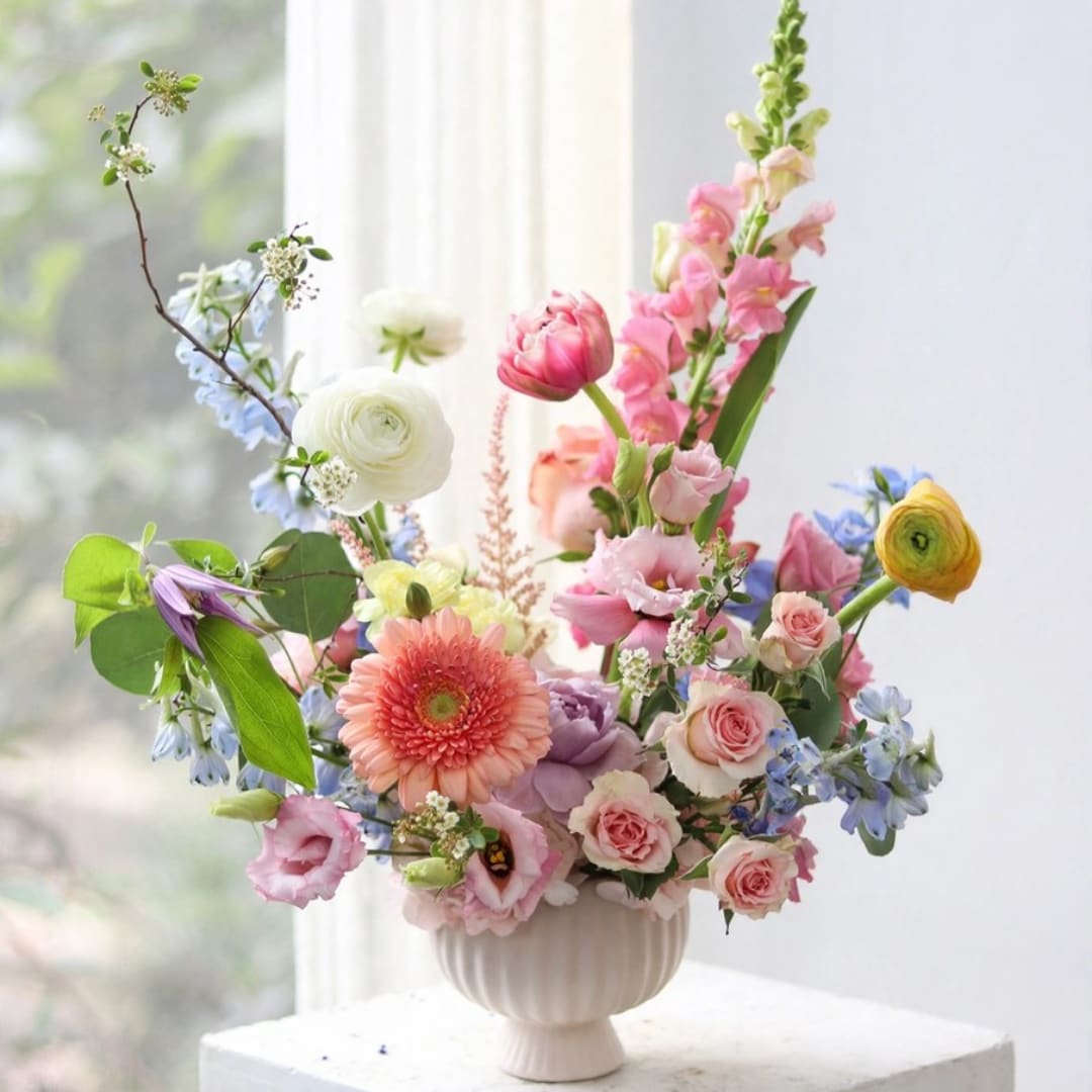 Colorful mixed flower arrangement in a white vase