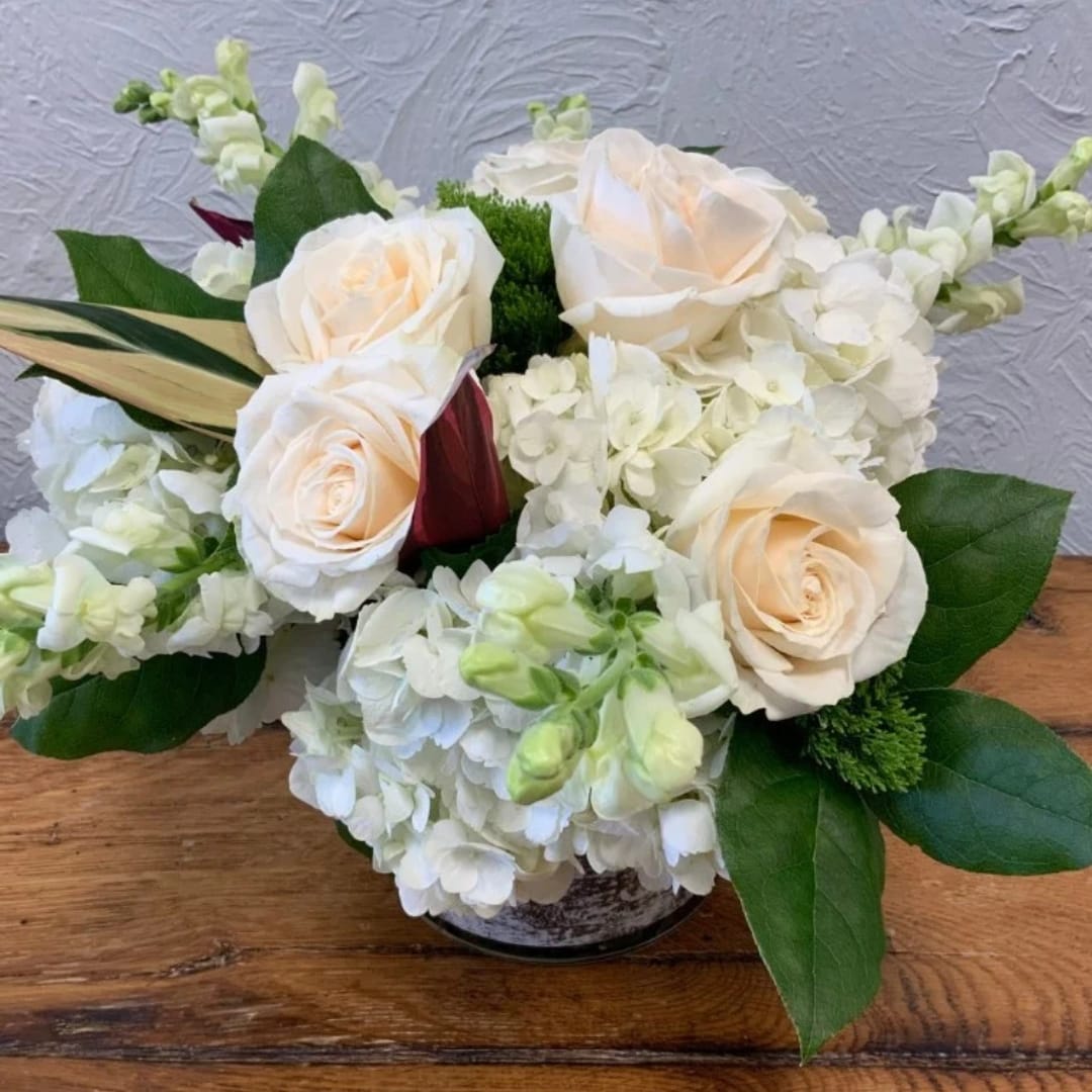 White roses and hydrangeas in a low vase arrangement