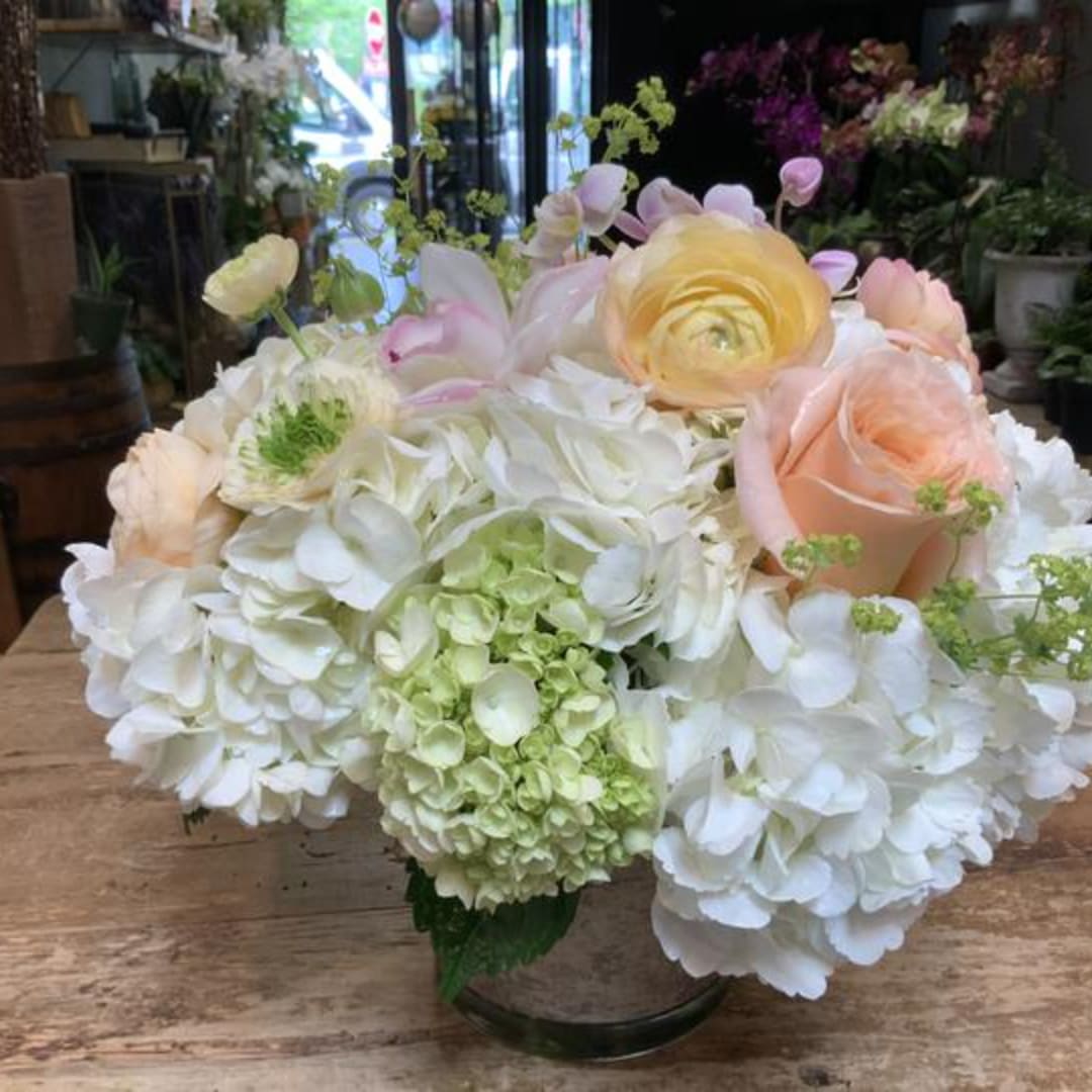 White and blush floral arrangement in a glass vase