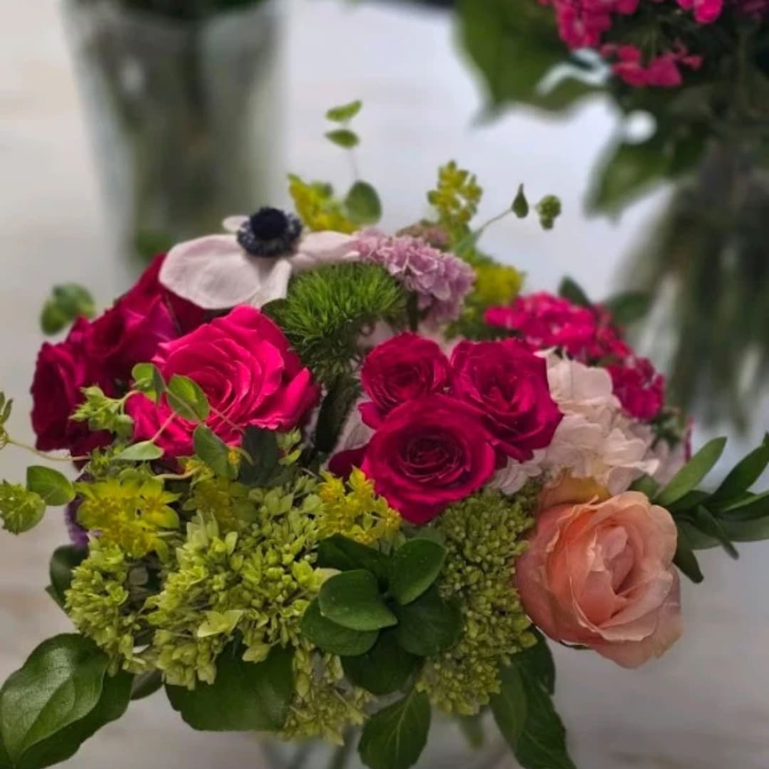 Bouquet of hot pink and peach roses with green filler flowers