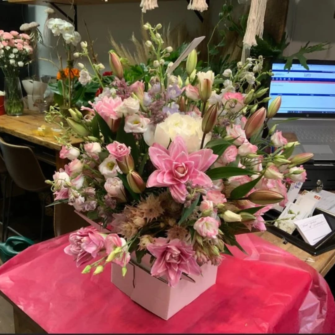 Pink and white wedding bouquet in a white box with lilies and roses