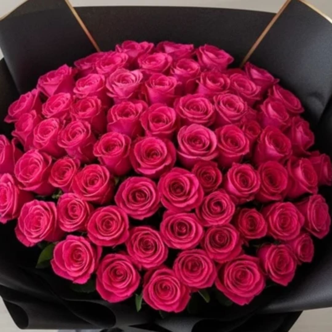 Bouquet of bright pink roses wrapped in black paper