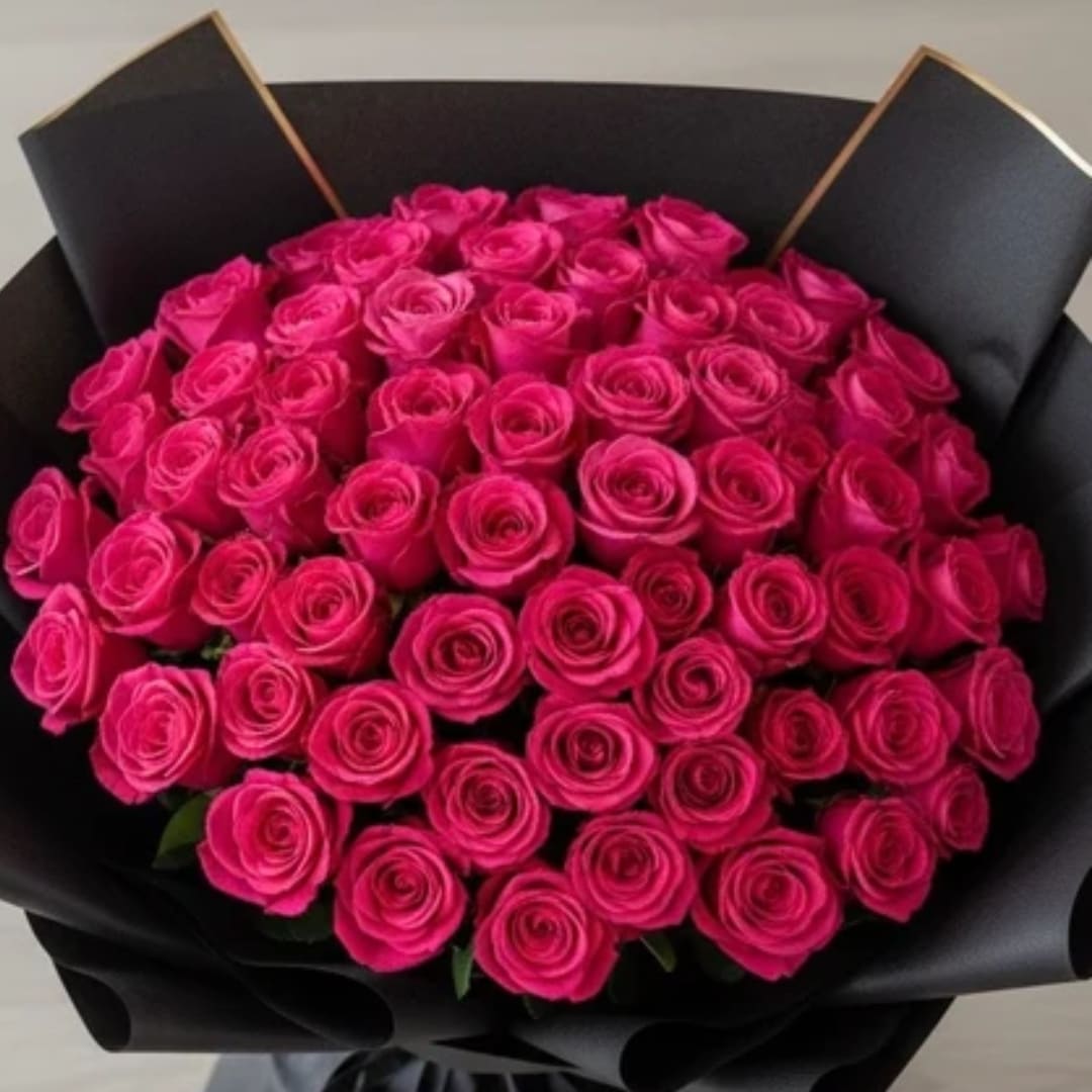 Bouquet of bright pink roses wrapped in black paper